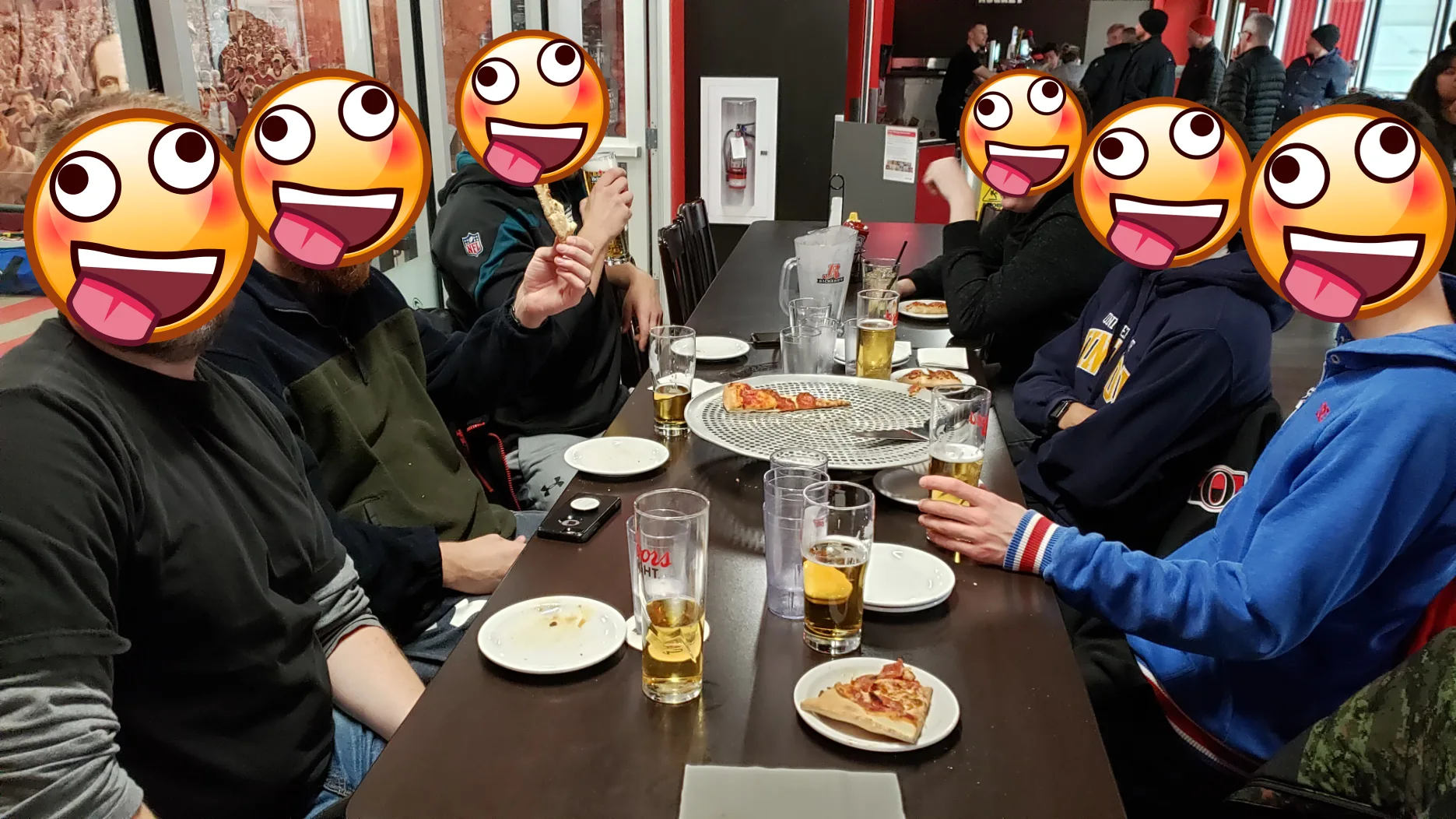 Coéquipiers entrain de festoyer après une victoire. Personnes entrain de boire de la bière et manger de la pizza.